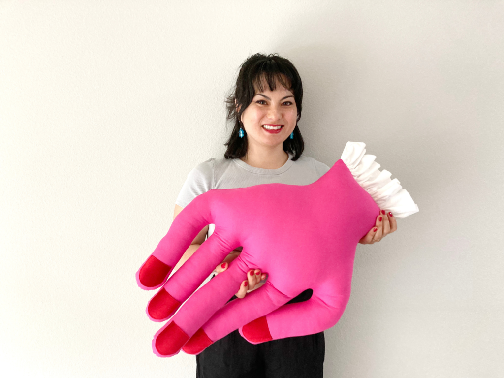 Sayuri holding a pink mini hand pillow