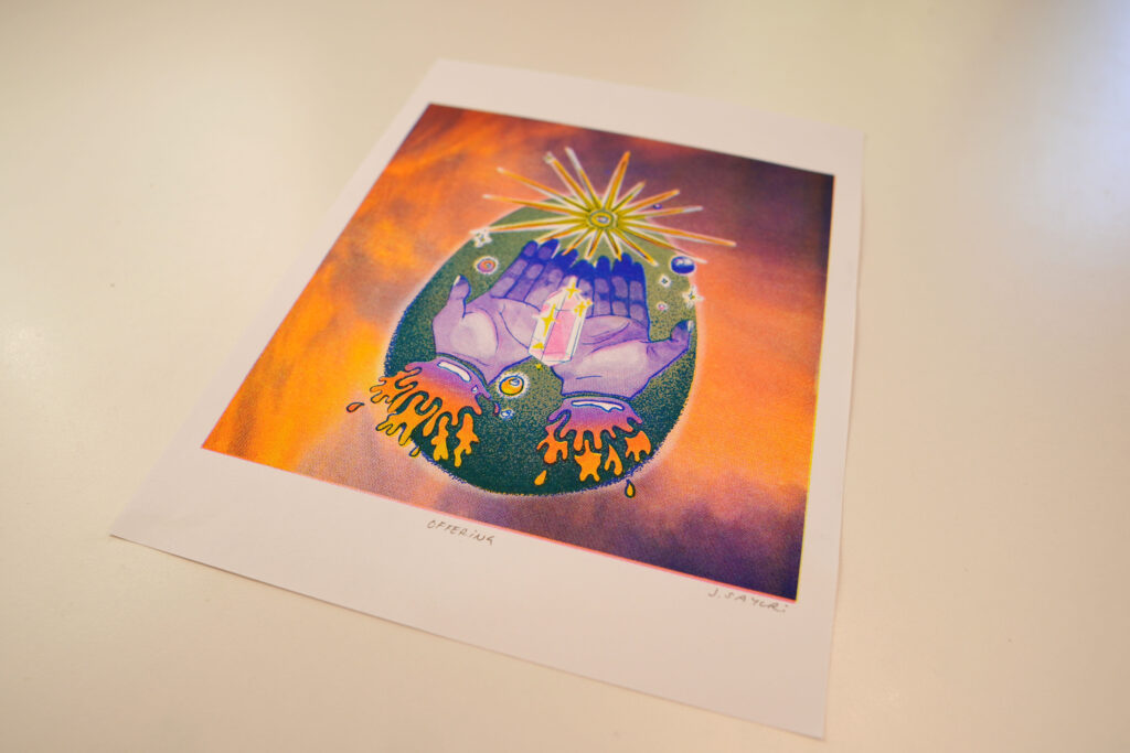 Offering risograph print at an angle, showing the white border and paper